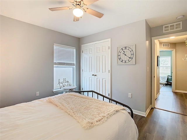 bedroom featuring wood finished floors, visible vents, and a closet