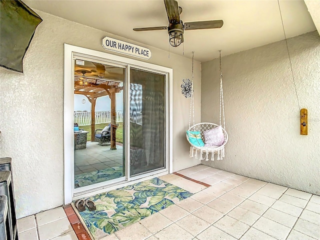 exterior space with stucco siding and a ceiling fan