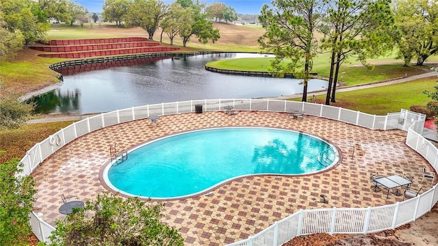 view of pool with a patio, a fenced in pool, fence, and a water view