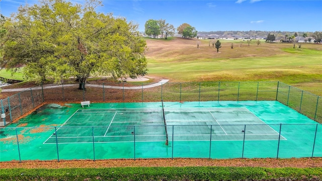 view of sport court featuring a yard and fence