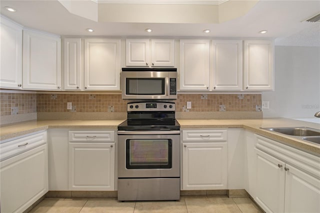 kitchen featuring a sink, white cabinetry, appliances with stainless steel finishes, and light tile patterned floors