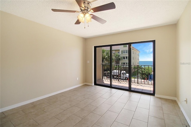 spare room with a ceiling fan, baseboards, and a textured ceiling