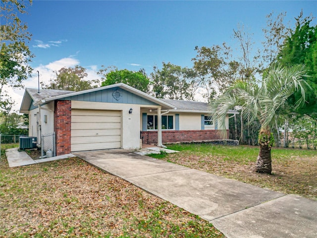 single story home featuring brick siding, an attached garage, fence, central AC, and driveway