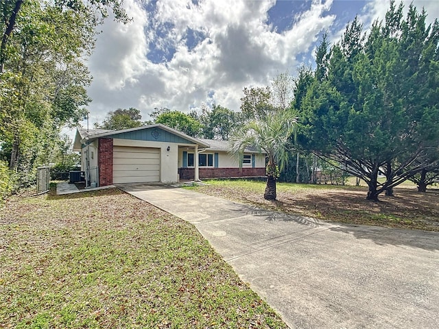 ranch-style home featuring brick siding, driveway, an attached garage, and a front yard