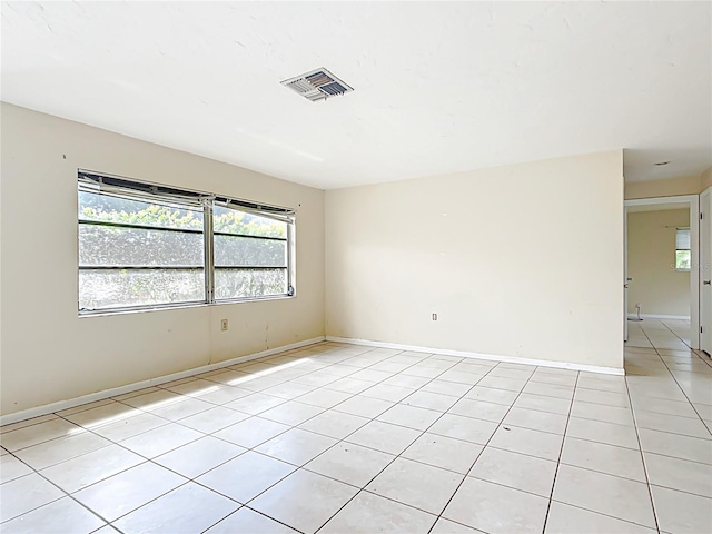 spare room featuring light tile patterned flooring, baseboards, and visible vents