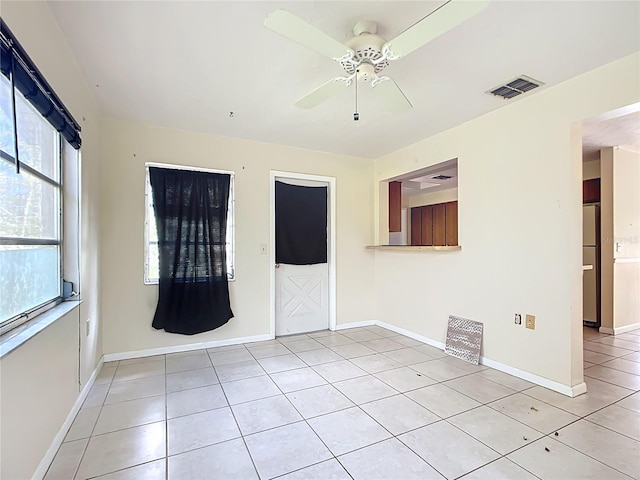 unfurnished room featuring visible vents, baseboards, light tile patterned flooring, and a ceiling fan