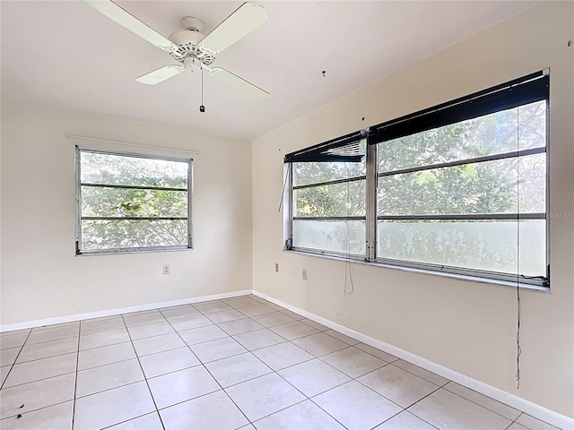 spare room featuring light tile patterned flooring, baseboards, and ceiling fan