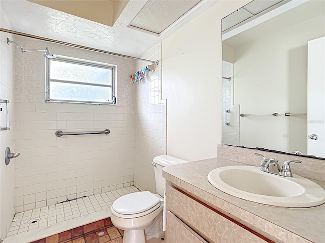 bathroom featuring tiled shower, toilet, and vanity