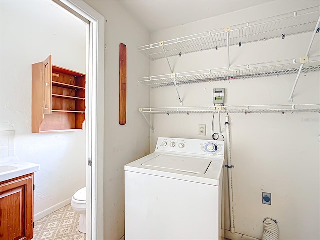 laundry room with baseboards, washer / clothes dryer, light floors, and laundry area