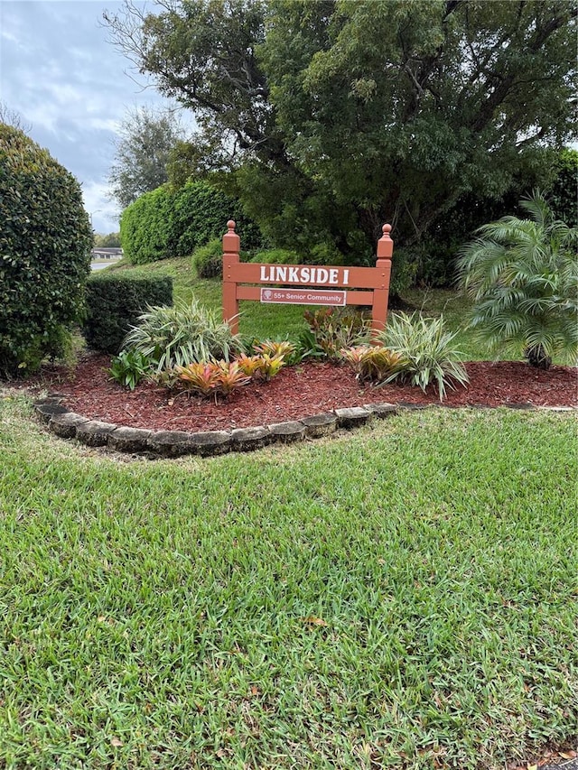 community / neighborhood sign featuring a lawn