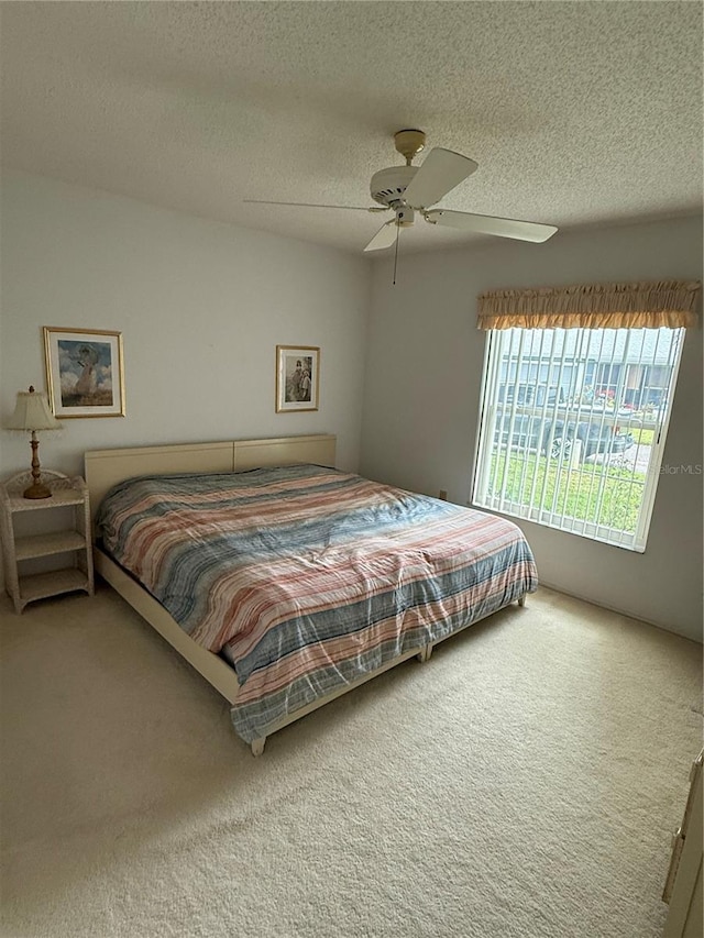 carpeted bedroom with a textured ceiling and ceiling fan