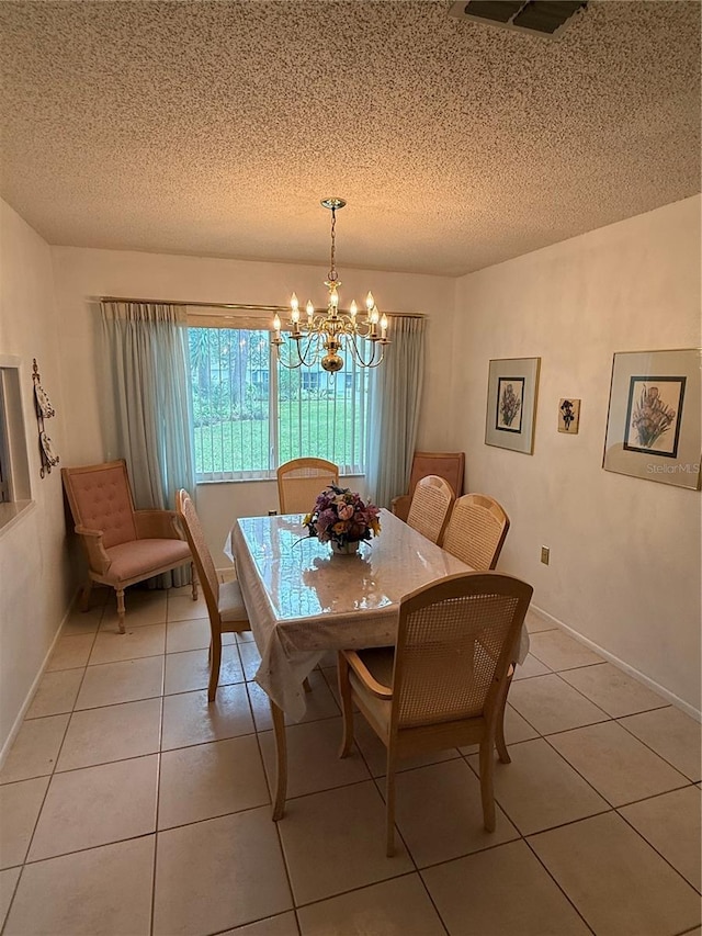 dining area featuring light tile patterned flooring, visible vents, a textured ceiling, and an inviting chandelier