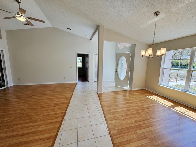 foyer entrance featuring a textured ceiling, ceiling fan with notable chandelier, visible vents, and light wood-type flooring