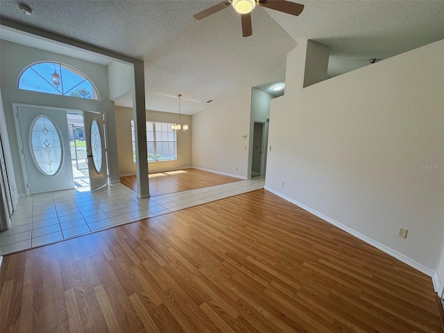 foyer entrance featuring lofted ceiling, wood finished floors, and a textured ceiling