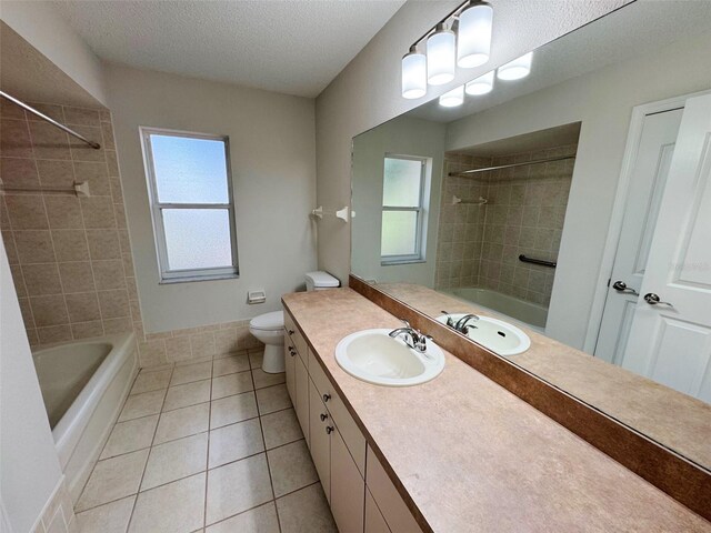 full bathroom with tile patterned flooring, a healthy amount of sunlight, a textured ceiling, and shower / bathing tub combination