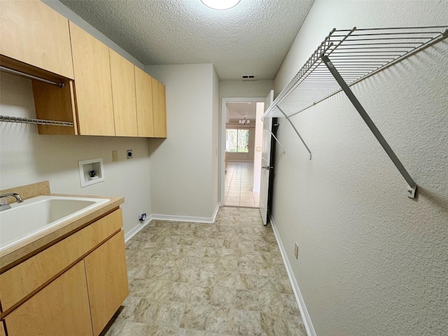 washroom with hookup for a washing machine, cabinet space, hookup for an electric dryer, a textured ceiling, and a sink