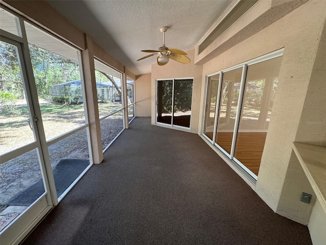 unfurnished sunroom featuring a ceiling fan and lofted ceiling