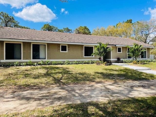 single story home with stucco siding and a front lawn