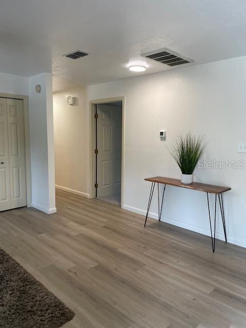 interior space with light wood-style flooring, baseboards, and visible vents