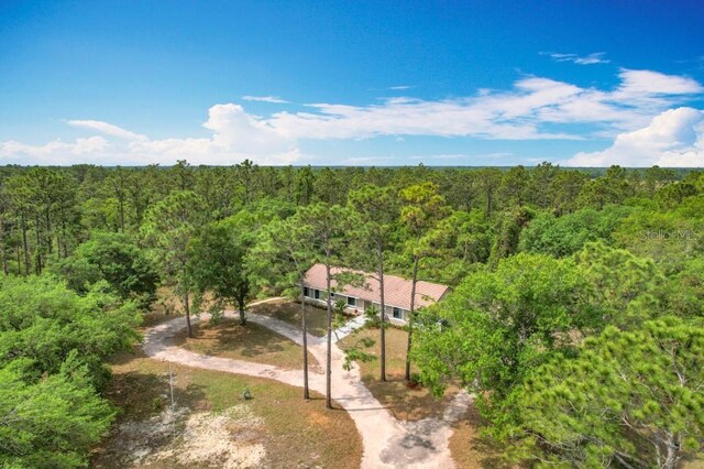 drone / aerial view featuring a wooded view