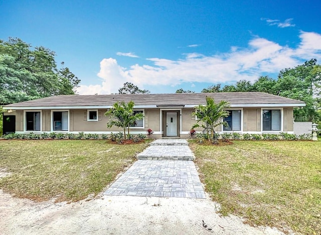 single story home featuring stucco siding and a front lawn
