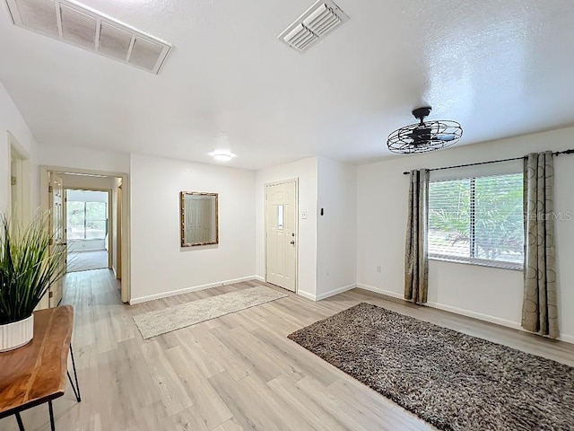 foyer featuring baseboards, visible vents, and light wood-style floors