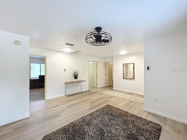 spare room featuring baseboards, visible vents, and light wood-style flooring