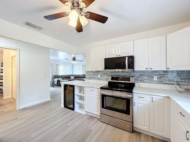 kitchen featuring backsplash, ceiling fan, white cabinets, visible vents, and appliances with stainless steel finishes