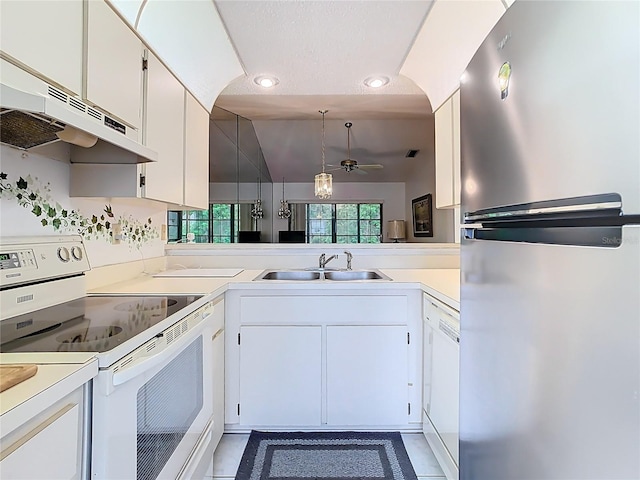 kitchen with under cabinet range hood, white appliances, light countertops, and a sink