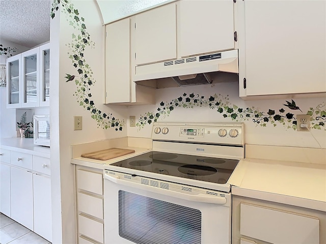 kitchen with under cabinet range hood, a textured ceiling, white cabinetry, white appliances, and light countertops