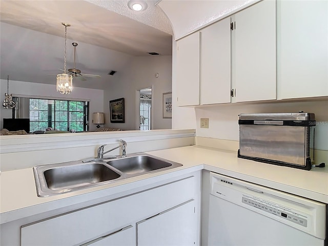 kitchen with dishwasher, light countertops, lofted ceiling, white cabinets, and a sink