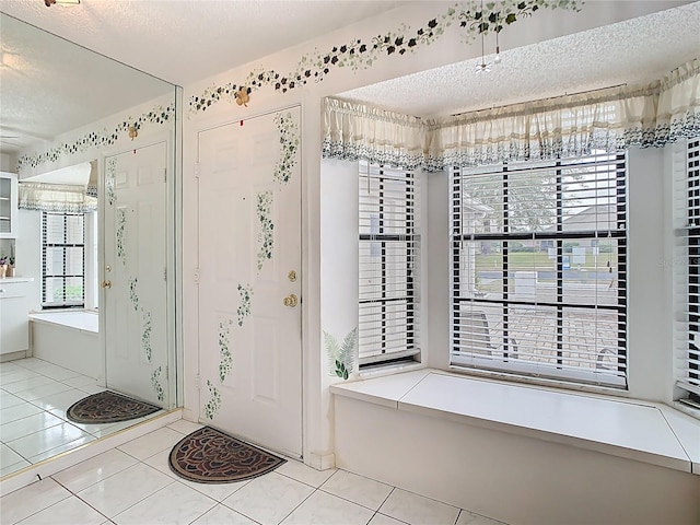 entrance foyer featuring tile patterned floors and a textured ceiling