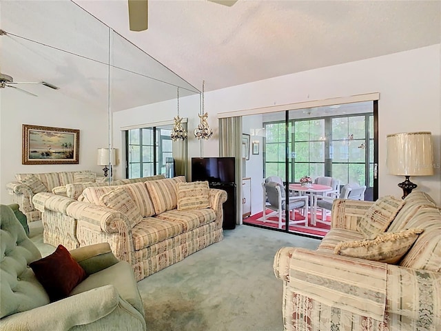 carpeted living room with a ceiling fan and vaulted ceiling