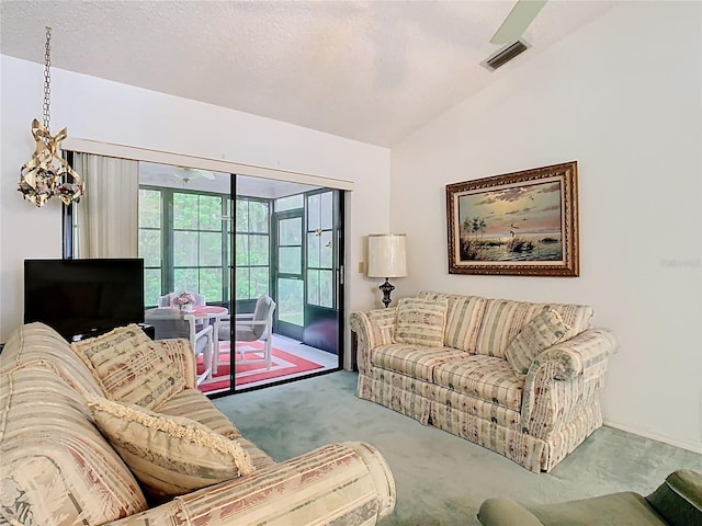 living room with vaulted ceiling, visible vents, carpet floors, and a textured ceiling