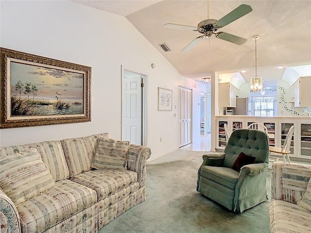 carpeted living room with vaulted ceiling, ceiling fan with notable chandelier, and visible vents