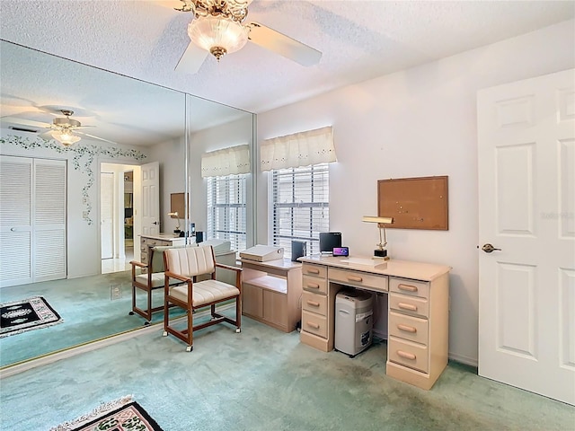 office with a textured ceiling, light colored carpet, and ceiling fan