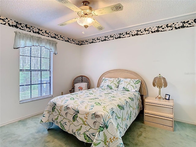 bedroom featuring baseboards, carpet, a ceiling fan, and a textured ceiling