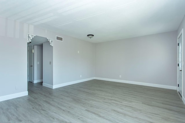 unfurnished room with light wood-style floors, visible vents, and baseboards