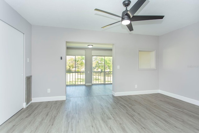 unfurnished room with visible vents, wood finished floors, baseboards, and ceiling fan