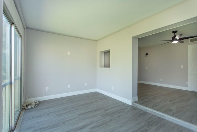 unfurnished room featuring ceiling fan, visible vents, baseboards, and wood finished floors