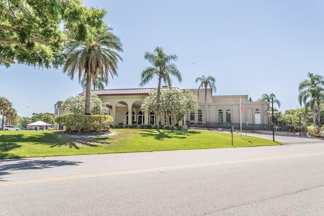 mediterranean / spanish home with stucco siding and a front lawn