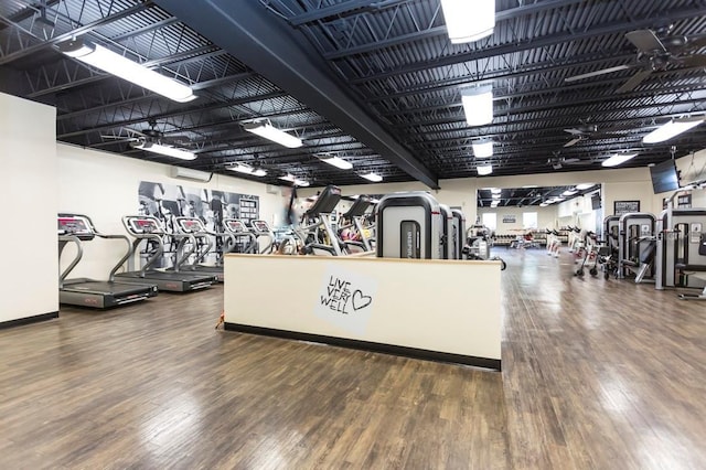 exercise room featuring wood finished floors and a wall mounted air conditioner