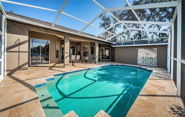 outdoor pool with glass enclosure and a patio