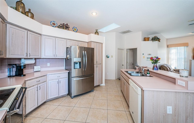 kitchen with light tile patterned floors, white dishwasher, electric range, stainless steel fridge, and a sink