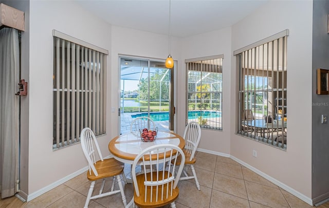 dining room with tile patterned floors, baseboards, and a sunroom