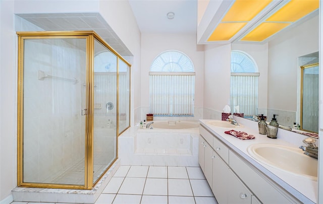 full bath featuring a bath, a shower stall, tile patterned floors, and a sink