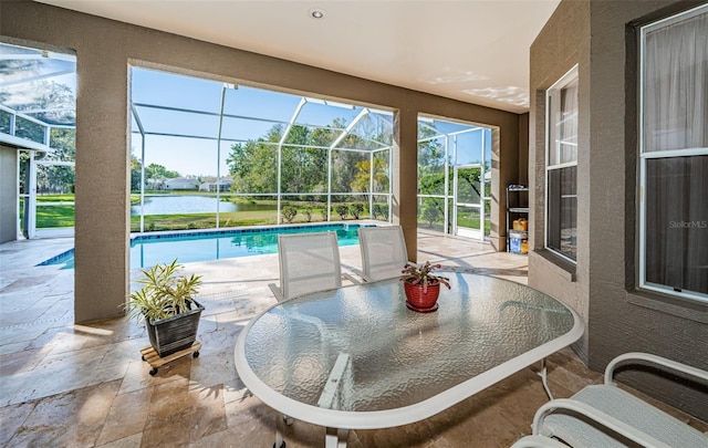 pool featuring glass enclosure, a water view, outdoor dining space, and a patio area