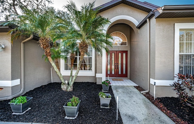 property entrance featuring french doors and stucco siding