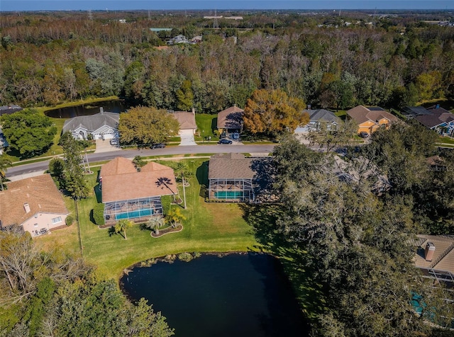 birds eye view of property featuring a forest view and a water view