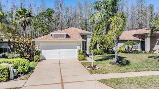 view of front of home with a garage, stucco siding, driveway, and a front lawn